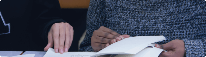 Duas estudantes lendo livro.